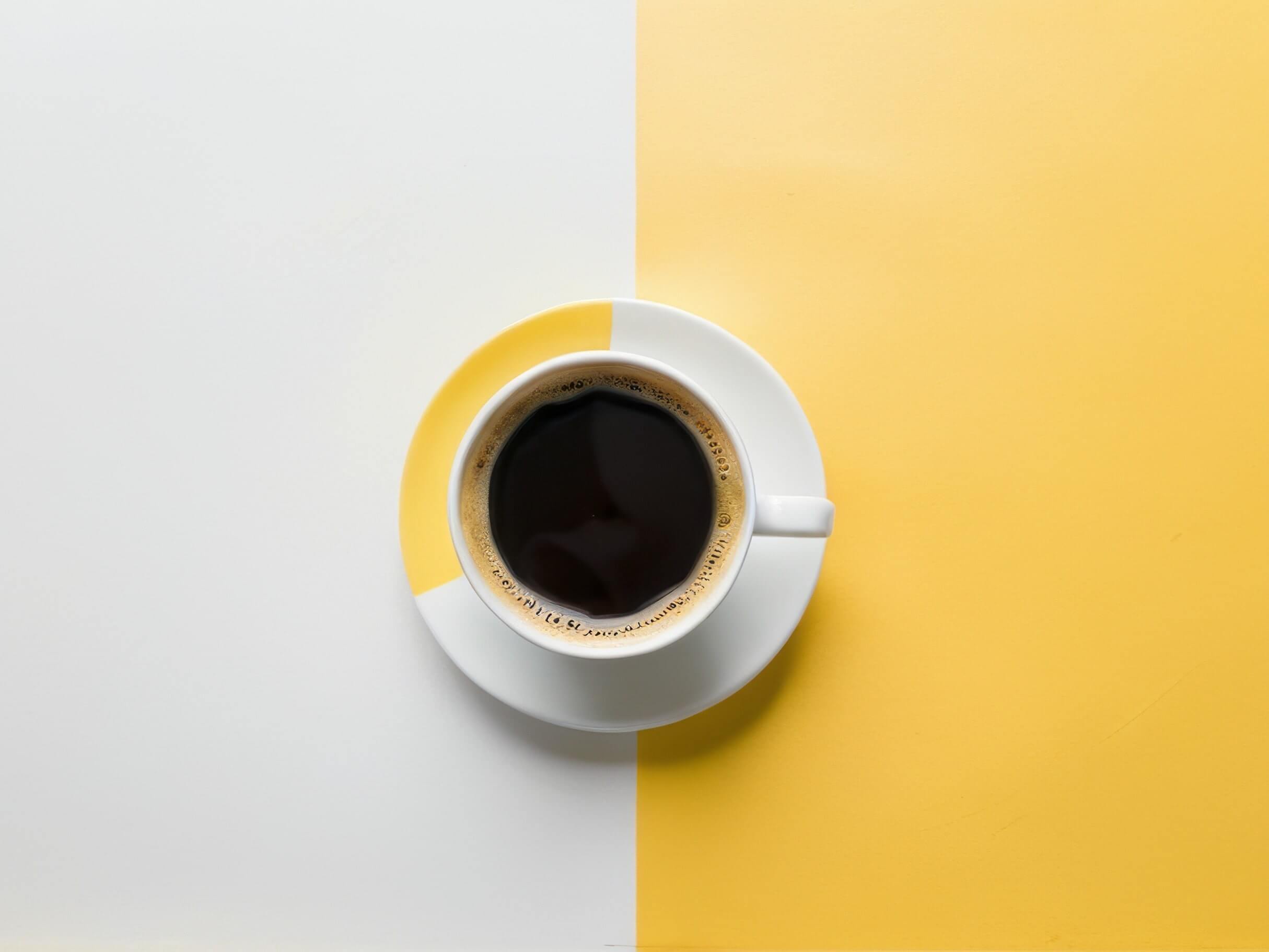 Tasse de café sur un fond jaune et blanc