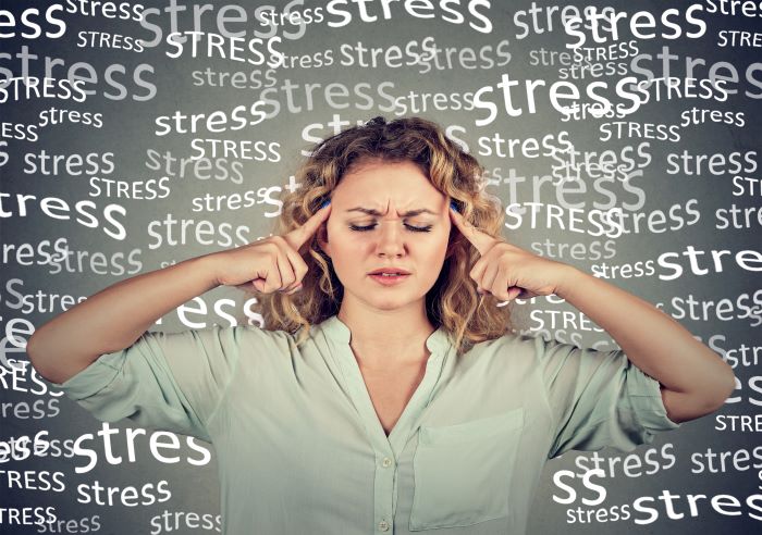 Femme qui ne supporte plus la quantité de stress, avec le mot stress tout autour d'elle