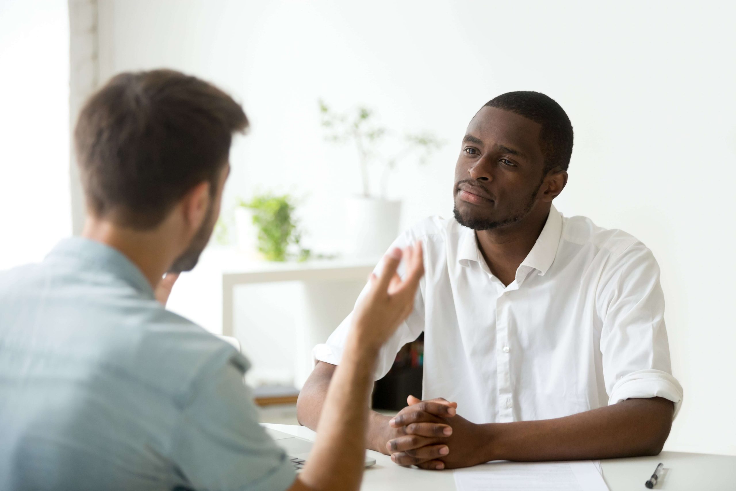 Un entretien avec deux hommes dont un de dos et un de face