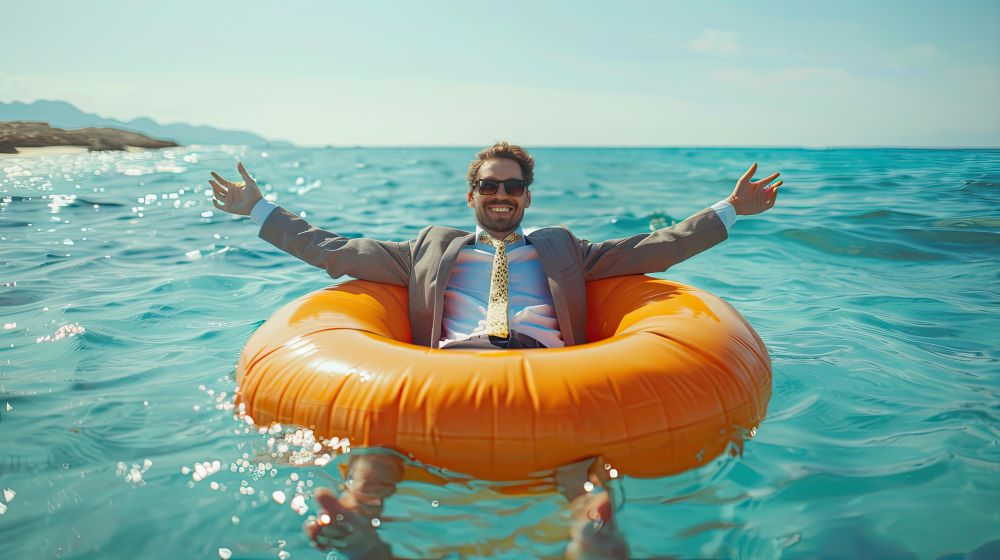 Homme qui est en costard sur une bouée dans la mer